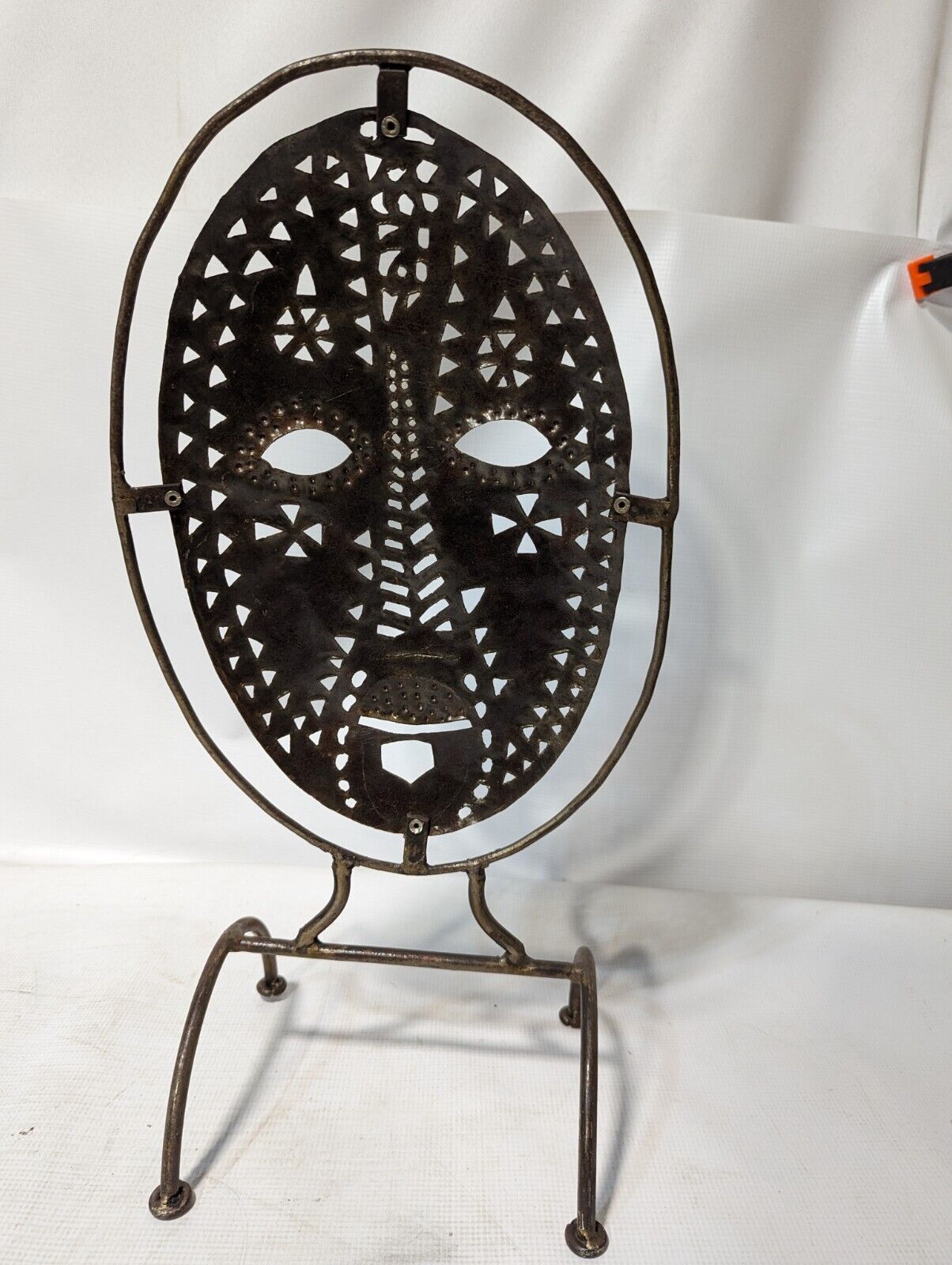 Metal mask on stand, 20.5 inches tall by 11 inches wide