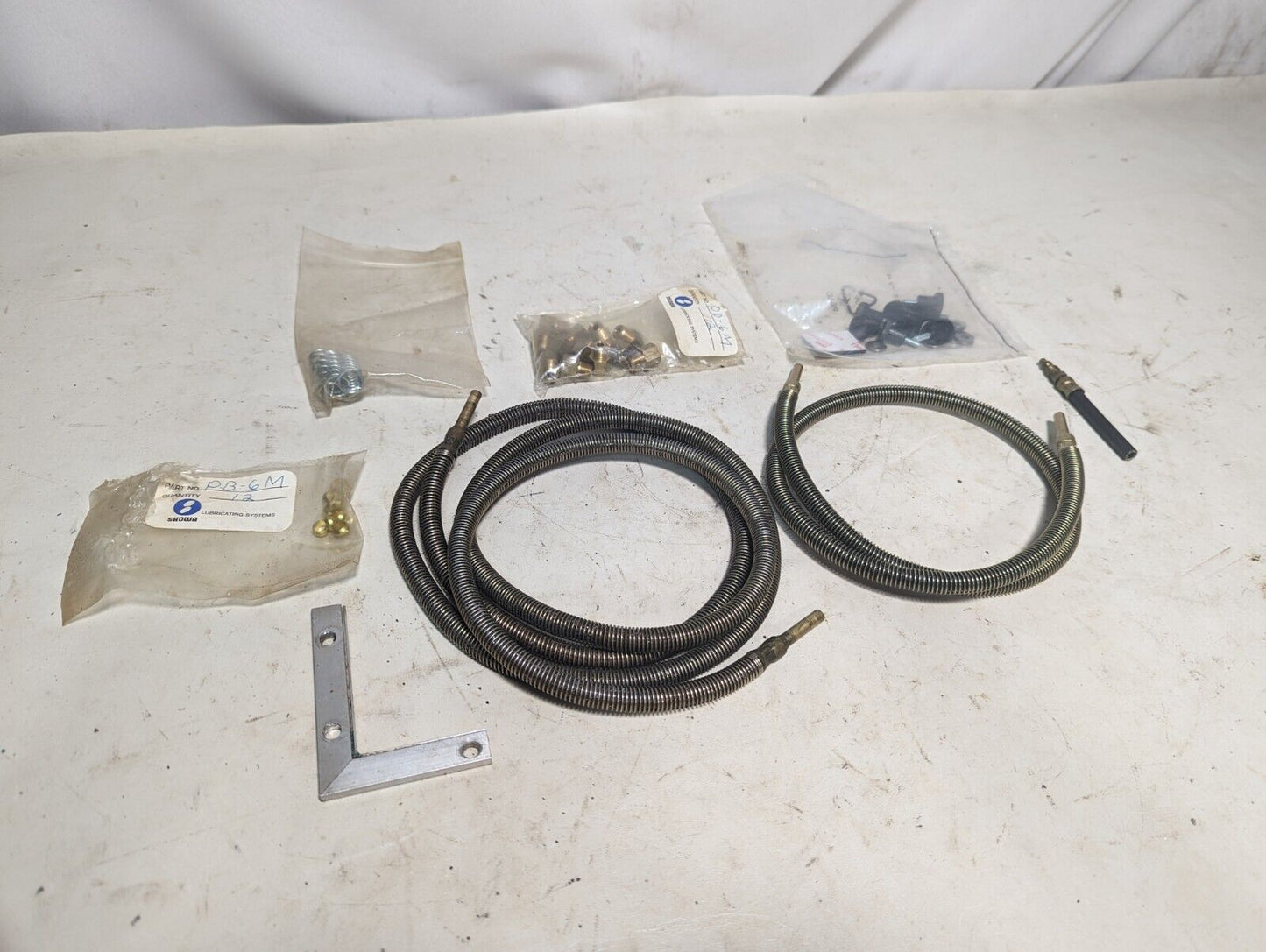 Lot of assorted Showa lubricating parts: two hoses, PB-6M, springs, PD-6M