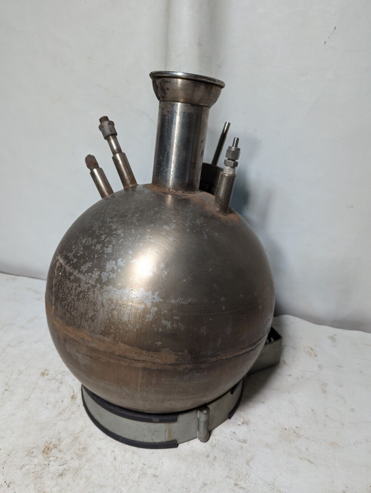 Unbranded stainless steel spherical kettle with stand, has some asphalt inside