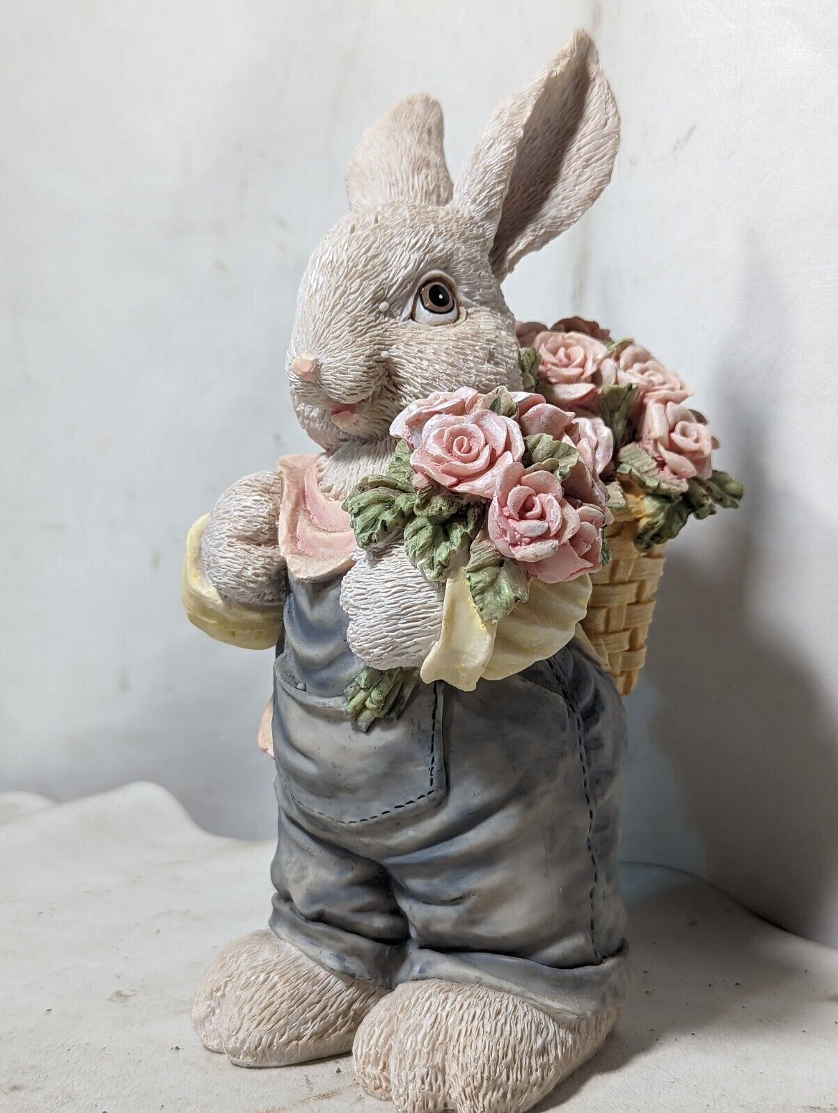 Rabbit in overalls carrying roses with basket backpack