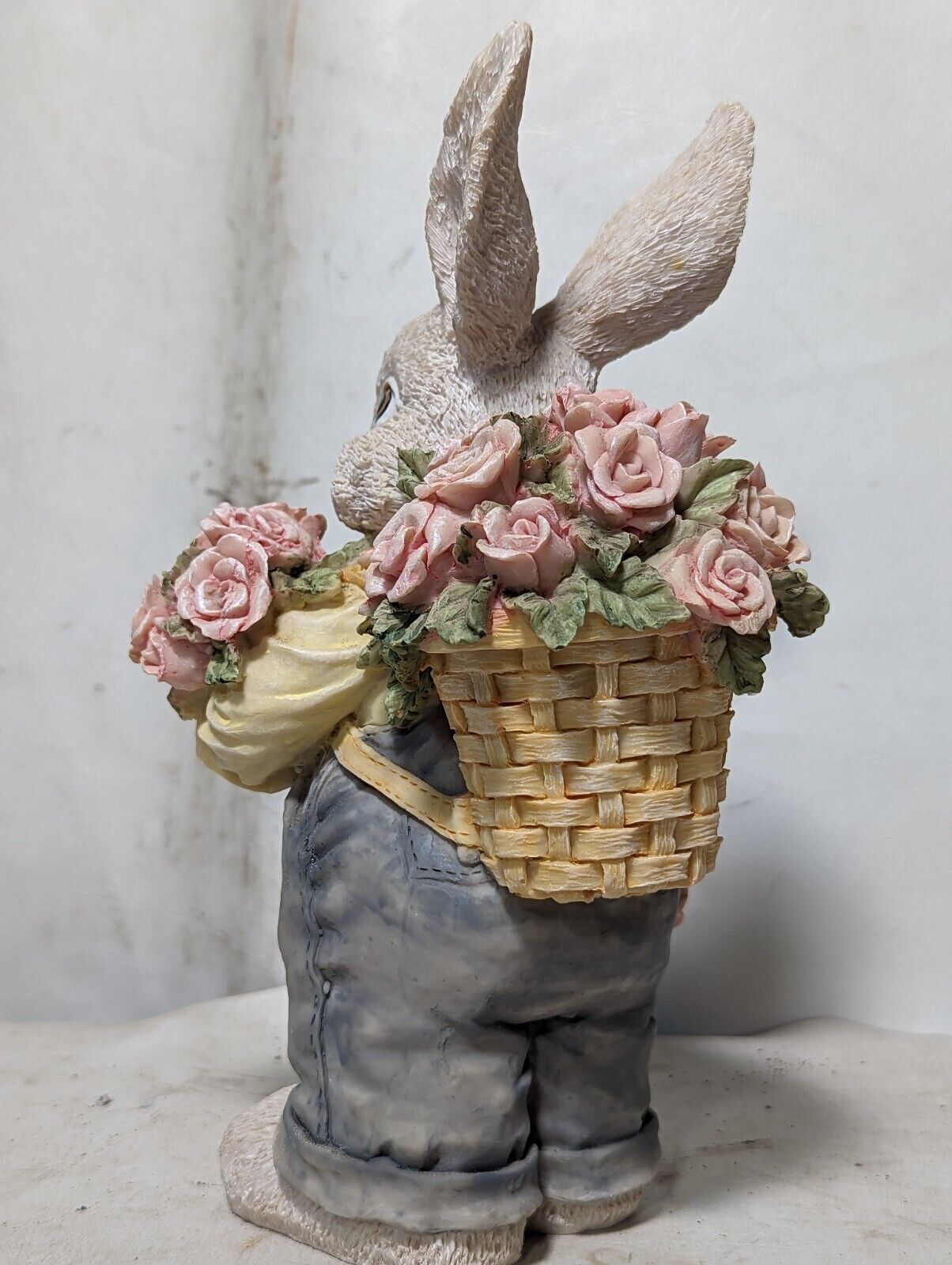 Rabbit in overalls carrying roses with basket backpack
